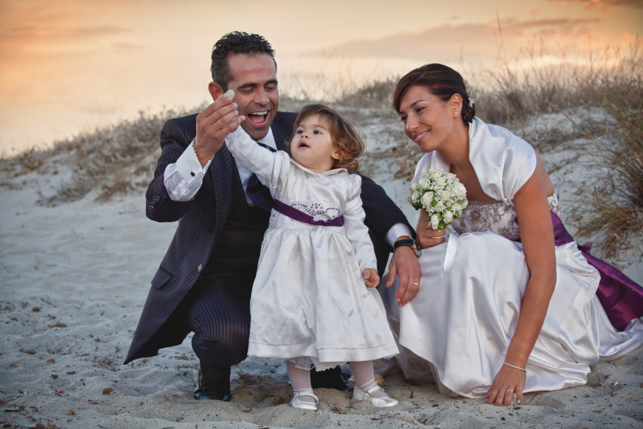 Famiglia felice in spiaggia nel giorno del matrimonio. Foto scattata da Giuseppe Ortu fotografo esperto in matrimoni a Olbia