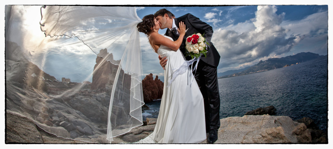 Sposi che si baciano sulla scogliera. Foto scattata in stile Fine Art dal fotografo olbiese Giuseppe Ortu. Fotografo matrimoni Olbia.