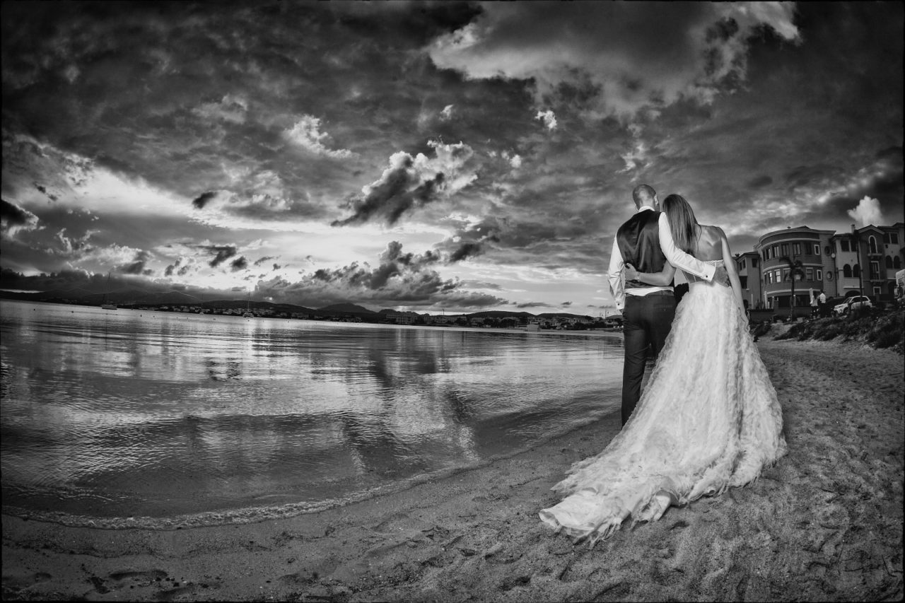 Sposini in riva al mare in bianco e nero. Foto scattata da Giuseppe Ortu fotografo specializzato in matrimoni a Olbia