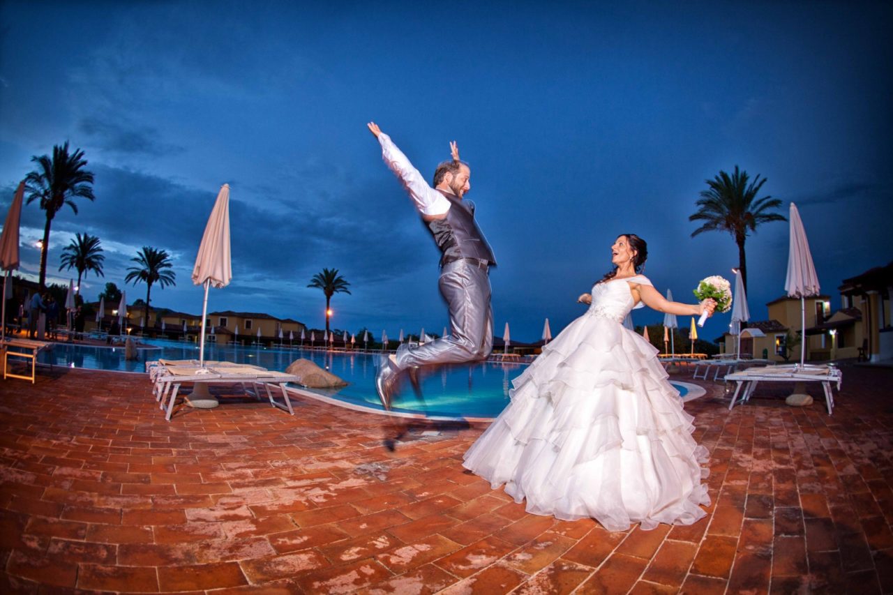 Sposi felici a bordo piscina. Foto scattata da Giuseppe Ortu fotografo specializzato in matrimoni a Olbia.